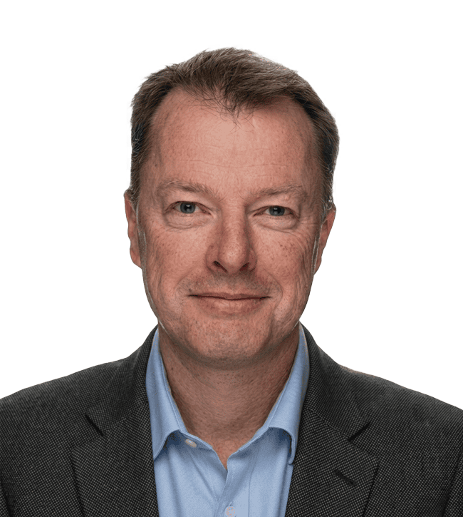 Head-and-shoulders portrait of a middle-aged man in a dark blazer and light blue shirt, smiling slightly.